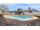 Backyard pool with concrete surround adjacent to a covered patio of a single-story home at 1747 W Belfast St, Mesa, AZ 85201