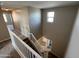 Carpeted staircase with white railing and window offers an attractive transition between floors in this home at 17541 W Lupine Ave, Goodyear, AZ 85338