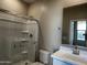 Clean bathroom featuring a glass-enclosed shower, white vanity, and a modern mirror at 17558 W Lupine Ave, Goodyear, AZ 85338