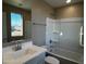 Well-lit bathroom featuring a single vanity, large mirror, and a bathtub-shower combination at 17558 W Lupine Ave, Goodyear, AZ 85338