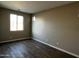 Bright bedroom featuring wood-look tile flooring, neutral paint, and a large window for natural light at 17558 W Lupine Ave, Goodyear, AZ 85338