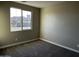 Comfortable bedroom featuring carpet flooring, neutral paint, and a large window providing plenty of light at 17558 W Lupine Ave, Goodyear, AZ 85338