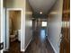 Welcoming entryway features wood-look tile flooring leading to an open floor plan and a view of the downstairs bathroom at 17558 W Lupine Ave, Goodyear, AZ 85338