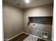 Bright laundry room with tile flooring, shelving, and utility connections at 17558 W Lupine Ave, Goodyear, AZ 85338