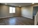 Spacious living room with wood-look tile flooring, recessed lighting, and a window providing natural light at 17558 W Lupine Ave, Goodyear, AZ 85338