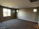 Spacious living room featuring neutral walls, carpet flooring, and natural light from the large window at 17558 W Lupine Ave, Goodyear, AZ 85338