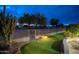 Tranquil backyard view featuring a putting green and mature trees under a night sky at 17642 N Ironhorse Dr, Surprise, AZ 85374