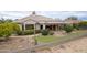 Aerial view of the backyard with a putting green and covered patio area for outdoor enjoyment at 17642 N Ironhorse Dr, Surprise, AZ 85374