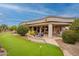 Backyard features a putting green and covered patio for relaxing and entertaining at 17642 N Ironhorse Dr, Surprise, AZ 85374