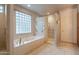 Bathroom with a large soaking tub, glass block window, and a separate walk-in shower at 17642 N Ironhorse Dr, Surprise, AZ 85374