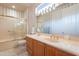 Bright bathroom with vanity, neutral tile floor, framed mirror, and shower over tub at 17642 N Ironhorse Dr, Surprise, AZ 85374