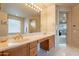 Bathroom vanity with double sinks, vanity lighting, a large mirror, and tiled flooring at 17642 N Ironhorse Dr, Surprise, AZ 85374