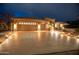 Attractive exterior with a three-car garage and a well-lit driveway at twilight at 17642 N Ironhorse Dr, Surprise, AZ 85374