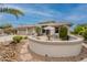 Charming exterior featuring a quaint patio with seating and desert landscaping during the day at 17642 N Ironhorse Dr, Surprise, AZ 85374