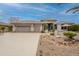 Attractive home exterior featuring a three-car garage and desert landscaping during the day at 17642 N Ironhorse Dr, Surprise, AZ 85374