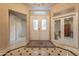 Elegant foyer features tile flooring, decorative glass double doors, and ornate chandelier at 17642 N Ironhorse Dr, Surprise, AZ 85374