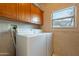 Bright laundry room area with white appliances, window, and tile flooring at 17642 N Ironhorse Dr, Surprise, AZ 85374