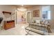 Relaxing living room with light tile flooring, sofa, glass coffee table, and hallway view at 17642 N Ironhorse Dr, Surprise, AZ 85374