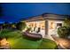 Inviting covered patio with outdoor seating overlooking a lush putting green at twilight at 17642 N Ironhorse Dr, Surprise, AZ 85374