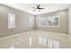 Spacious bedroom featuring glossy tile flooring, a ceiling fan, and bright windows at 1800 N 156Th Dr, Goodyear, AZ 85395