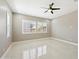 Bright, empty bedroom showcasing glossy tile flooring and large windows with white shutters at 1800 N 156Th Dr, Goodyear, AZ 85395