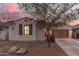 Exterior of home with desert landscaping and a front yard tree at 1800 N 156Th Dr, Goodyear, AZ 85395