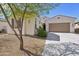 Home exterior with a three-car garage, desert landscaping, and paver driveway at 1800 N 156Th Dr, Goodyear, AZ 85395