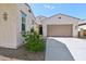 Beautiful home featuring a spacious two-car garage, neutral stucco, desert landscaping, and a welcoming entrance at 1800 N 156Th Dr, Goodyear, AZ 85395