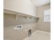 Bright laundry room with functional shelving, modern utilities and natural lighting from the adjacent window at 1800 N 156Th Dr, Goodyear, AZ 85395