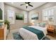 Bedroom showcasing a ceiling fan, bright windows with white shutters, and tile flooring at 1800 N 156Th Dr, Goodyear, AZ 85395