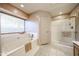 Bathroom featuring a soaking tub, shower, and window at 18660 N 71St Ln, Glendale, AZ 85308