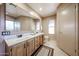 Bathroom featuring a dual sink vanity with a large mirror and wood drawers at 18660 N 71St Ln, Glendale, AZ 85308