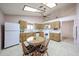 Bright eat-in kitchen featuring ceiling fan, vaulted ceilings, tile flooring, wood cabinets, and round wood dining table at 18660 N 71St Ln, Glendale, AZ 85308