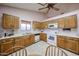 Spacious kitchen featuring tile flooring, light-colored walls, wood cabinets, and white appliances at 18660 N 71St Ln, Glendale, AZ 85308