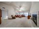 Spacious living room features vaulted ceilings, a fan, plush carpeting, and a fireplace for a warm ambiance at 18660 N 71St Ln, Glendale, AZ 85308