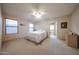 This spacious main bedroom offers a ceiling fan, ample natural light, and a serene view to the en-suite bathroom at 18660 N 71St Ln, Glendale, AZ 85308