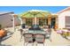 Enjoy outdoor dining on the covered patio with comfortable seating and an umbrella at 20047 N Shadow Mountain Dr, Surprise, AZ 85374