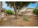 Spacious backyard featuring desert landscaping, mature trees, and a retaining wall at 26065 N 68Th Ln, Peoria, AZ 85383