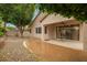 Rear exterior featuring desert landscaping, covered patio and mature shade tree at 26065 N 68Th Ln, Peoria, AZ 85383