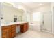 Bright main bathroom featuring double sinks, a soaking tub, and a walk-in shower at 26065 N 68Th Ln, Peoria, AZ 85383