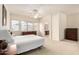 Light-filled main bedroom with a ceiling fan, carpeted floors, and a large window at 26065 N 68Th Ln, Peoria, AZ 85383