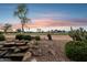 Scenic backyard featuring a rock waterfall, desert landscaping, and views of the lush golf course at 2634 N 164Th Ave, Goodyear, AZ 85395