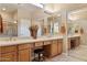 Bright bathroom featuring dual sinks, mirrors, wood cabinets, and a walk-in shower at 2634 N 164Th Ave, Goodyear, AZ 85395