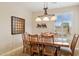 Dining area with wooden table, six chairs, modern light fixture and plantation shutters at 2634 N 164Th Ave, Goodyear, AZ 85395