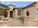 Inviting front entry with potted plants, decorative stone planters, and a pathway to the front door at 2634 N 164Th Ave, Goodyear, AZ 85395