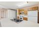 Cozy kitchen featuring wood cabinets, white appliances, and a peninsula sink at 3129 W Mohawk Ln, Phoenix, AZ 85027