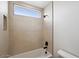 Bright bathroom with a sleek bathtub, tiled walls, and a transom window at 33949 N Borgata Trl, San Tan Valley, AZ 85144