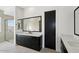 Modern bathroom featuring black cabinetry, a large mirror, and a glass-enclosed shower at 33949 N Borgata Trl, San Tan Valley, AZ 85144