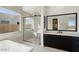 Modern bathroom featuring tub, glass shower, black cabinetry, and large window at 33949 N Borgata Trl, San Tan Valley, AZ 85144