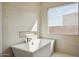 Bright bathroom featuring a standalone tub and large window at 33949 N Borgata Trl, San Tan Valley, AZ 85144